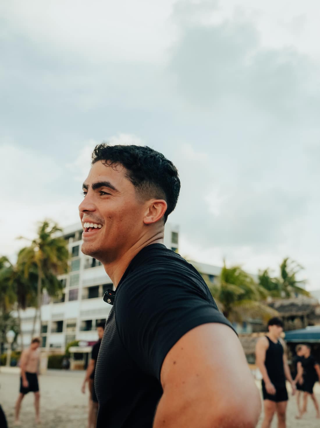 Jovany Ruiz smiling on the beach in front of a THRVE group